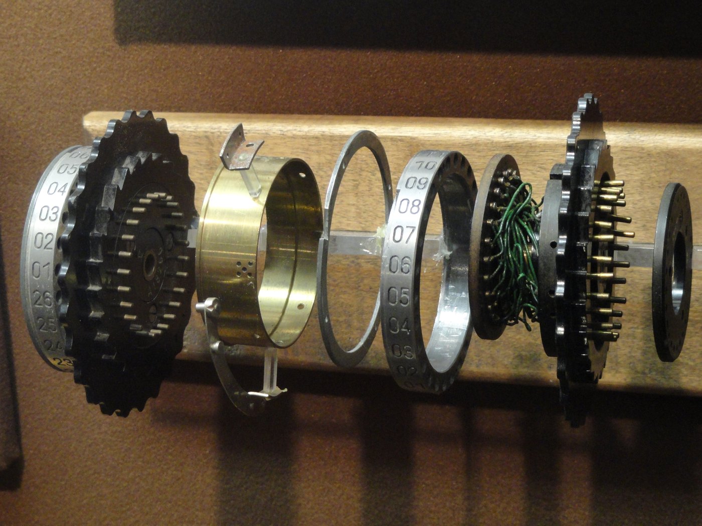 Figure 2 — 4 — A wired Enigma rotor: the ring of sprung pin-and-plate contacts, the ratchet, and the notch — the mechanical vocabulary the Covert Bombe theme borrows. Photo: File:ENIGMA Wired Rotor -…