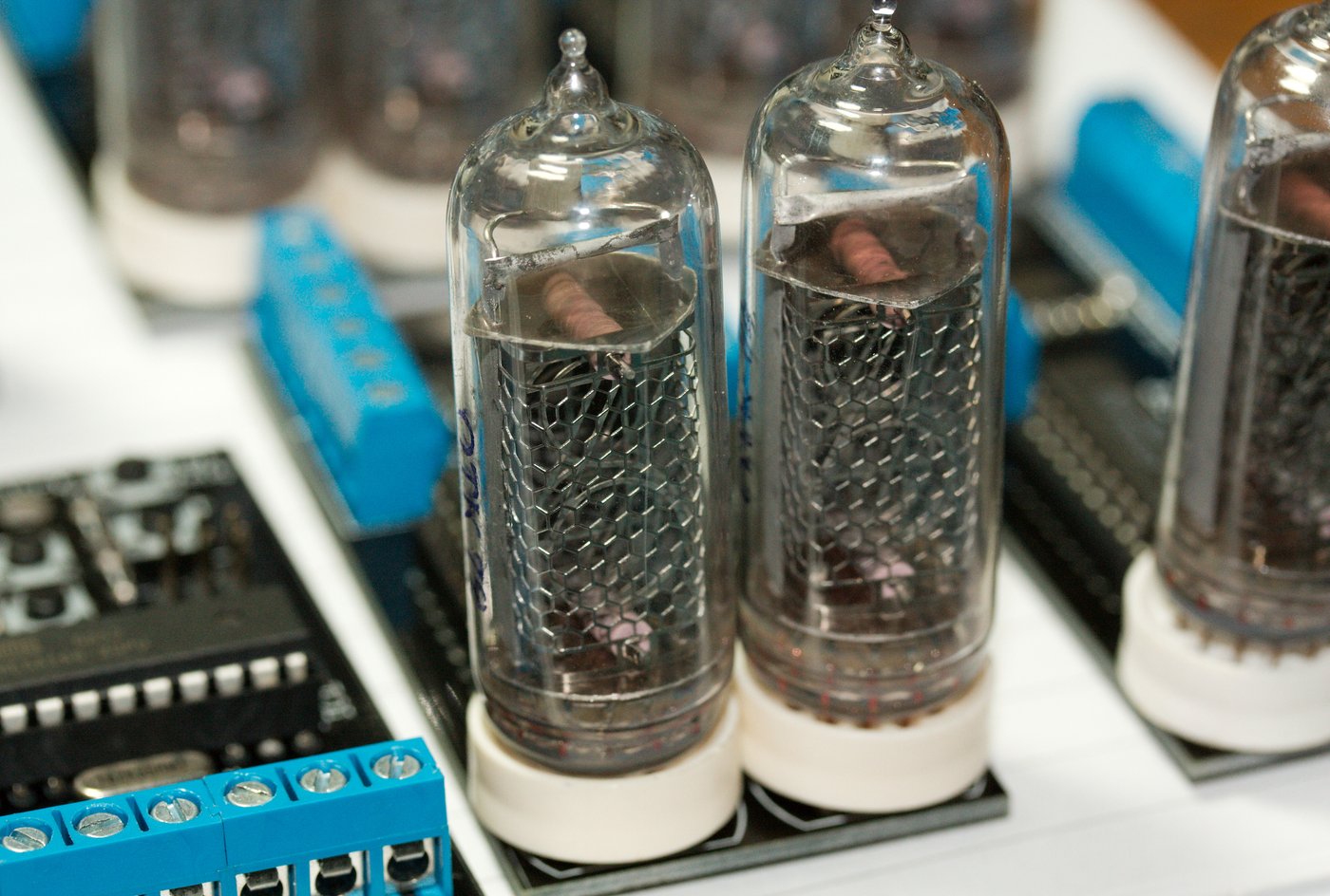 Figure 5 — 6 — Two Soviet IN-14 tubes, the side-view standard: upright numerals read through the side of the glass, the wire anode mesh standing in front of the stacked cathodes. The IN-14 is the mos…